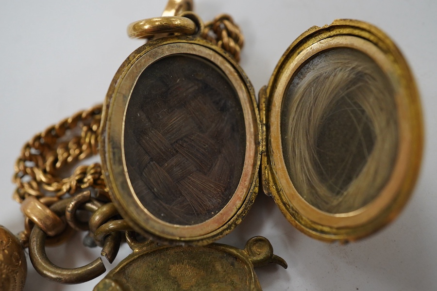 A Victorian yellow metal oval locket, with rope twist band, overall 29mm and a yellow metal fob chain. Condition - fair